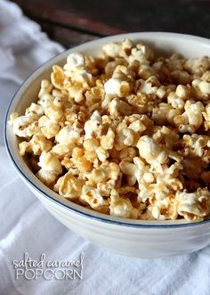 a bowl filled with popcorn sitting on top of a white cloth next to a wooden table