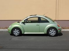 a small green car parked in front of a building