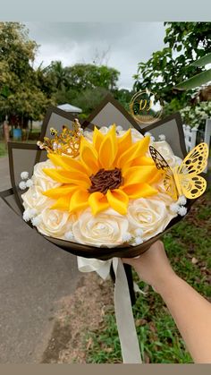 a person holding a bouquet with flowers and butterflies on it