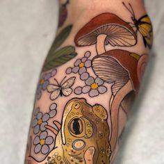 a close up of a person's leg with tattoos on it and a frog