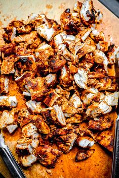 a wooden cutting board topped with sliced chicken and other food items on top of it