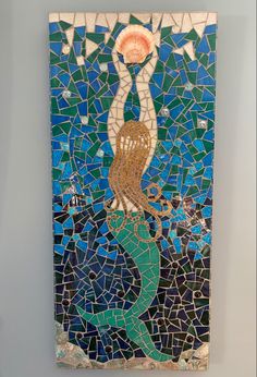 a piece of art that looks like a mermaid with a sun in her hand on the wall