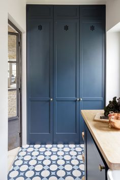 a kitchen with blue cabinets and white counter tops