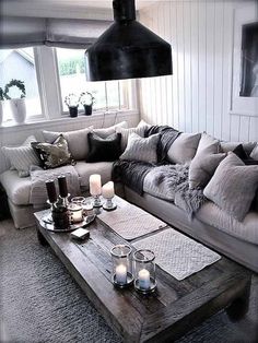 a living room filled with lots of furniture and candles on top of a coffee table