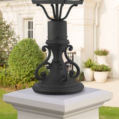 a black lamp post in front of a white house