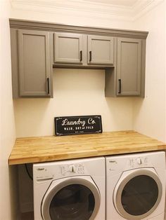 a washer and dryer in a laundry room with cabinets above it that says laundry co