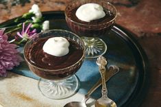 two desserts on a plate with spoons and flowers