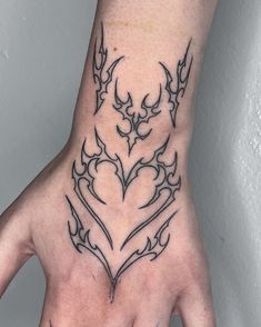 a person's hand with a tattoo design on it