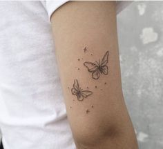 a woman's arm with two butterflies tattoo on the left side of her arm