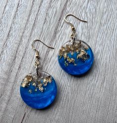 blue and gold earrings with flowers on them