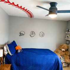 a bed room with a neatly made bed and two stuffed animals on the wall next to it