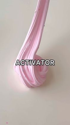 a pink vase sitting on top of a white table next to a sign that says activator