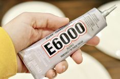 a person holding a tube of toothpaste in their left hand with the word e 6000 on it