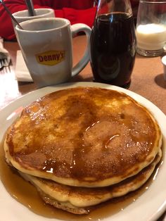 two pancakes on a white plate with syrup