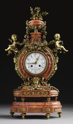 an ornate clock with cherubs on the face and sides, sitting on a stand