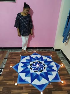 a woman standing on the floor in front of a blue and white star design rug