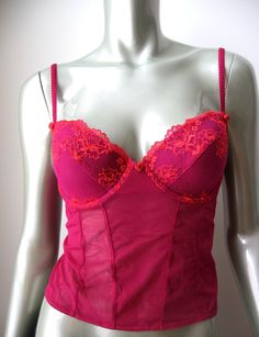 This hot berry color  camisole tank top is constructed of sheer mesh with padded contour underwire cups covered with gorgeous floral embroidery. Sheer stretch mesh bodice with rear 3 column, 1 row hook and eye cushioned back closure. Stretch rear adjustable straps with silk rose at front. One silk rose centered at gore. A stunning piece to make you feel special and captivating! Style No.:  Color: Berry Size: 36B Materials: 58% Nylon, 30% Rayon, 12% Spandex Condition: Brand new With Tag Inventory# VI0053 Berry Color, Silk Rose, Silk Roses, Tank Top Camisole, Feel Special, Feeling Special, No Color, Cami Tanks, Floral Embroidery