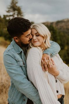 a man and woman embracing each other in a field