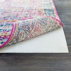 the rug is laying on top of the wooden floor and it has a colorful pattern