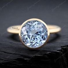 an oval blue diamond sits on top of a wooden surface, with the words treasure written in