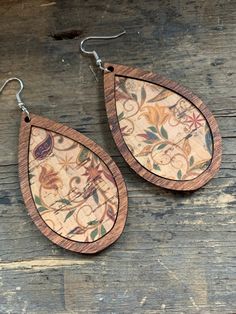 two wooden earrings with floral designs on them