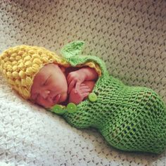 a newborn baby wearing a green and yellow hat