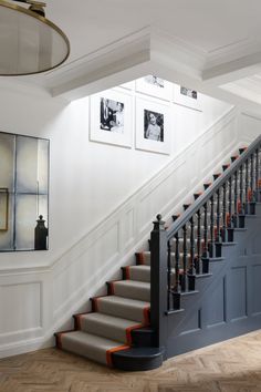 a staircase with pictures on the wall next to it