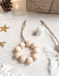 the wooden bead necklace is on display next to pine cones and other decorations, including a star ornament