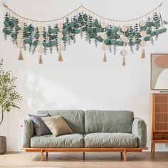 a living room with a couch, table and potted plant on the wall next to it