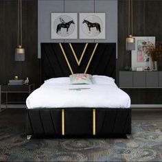 a black and gold bed in a bedroom with two pictures on the wall above it