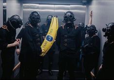 a group of people wearing gas masks and holding a banana in front of their faces