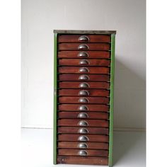 an old wooden drawer with metal balls on it's sides and green trim around the drawers