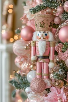 a nutcracker ornament hanging from a christmas tree with pink ornaments around it