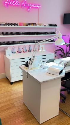 a nail salon with pink walls and white desks