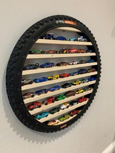 a toy car display in the shape of a tire is mounted on a wall with shelves