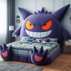 a bed with an odd looking monster head on it's head and two smaller monsters at the foot