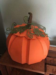 a paper pumpkin sitting on top of a wooden table