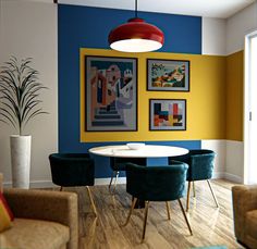 a blue and yellow dining room with art hanging on the wall, chairs around a white table