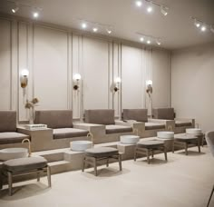 an empty waiting room with several chairs and stools in front of the wall lights