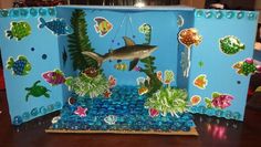 an ocean scene made out of plastic bottles and seaweed with a shark in the background