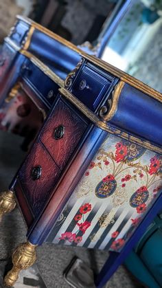 an ornate blue and gold painted desk with drawers