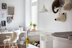 a child's bedroom with white walls and wooden floors, decorated with animal head wall hangings