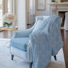 a blue chair sitting on top of a wooden floor next to a white rug and fireplace