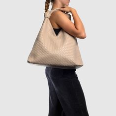 The Como Shoulder Bag by Urban Originals is a stylish double knot hobo crafted from woven vegan leather. Designed to be roomy, it effortlessly accommodates your everyday essentials with flair. Woven Leather Hobo Tote Bag For On-the-go, Chic Woven Leather Hobo Bag For On-the-go, Modern Woven Leather Hobo Bag For Daily Use, Modern Woven Hobo Bag With Double Handle, Modern Woven Double Handle Hobo Bag, Intrecciato Weave Hobo Shoulder Bag For On-the-go, Modern Woven Leather Hobo Bag For Travel, Versatile Rectangular Hobo Bag With Braided Handles, Modern Travel Hobo Bag In Woven Leather