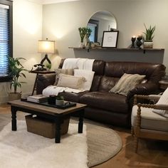 a living room filled with furniture and a large mirror on the wall above it's windows