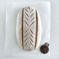 a piece of bread sitting on top of a white napkin next to a coin and paper