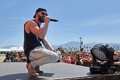 a man with a microphone on top of a stage in front of a large crowd