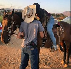 a man and woman riding on the back of a brown horse next to each other