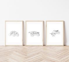 three framed drawings of cars are on the wall next to a chevron wood floor