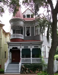 an old victorian style house with white trim and red roof